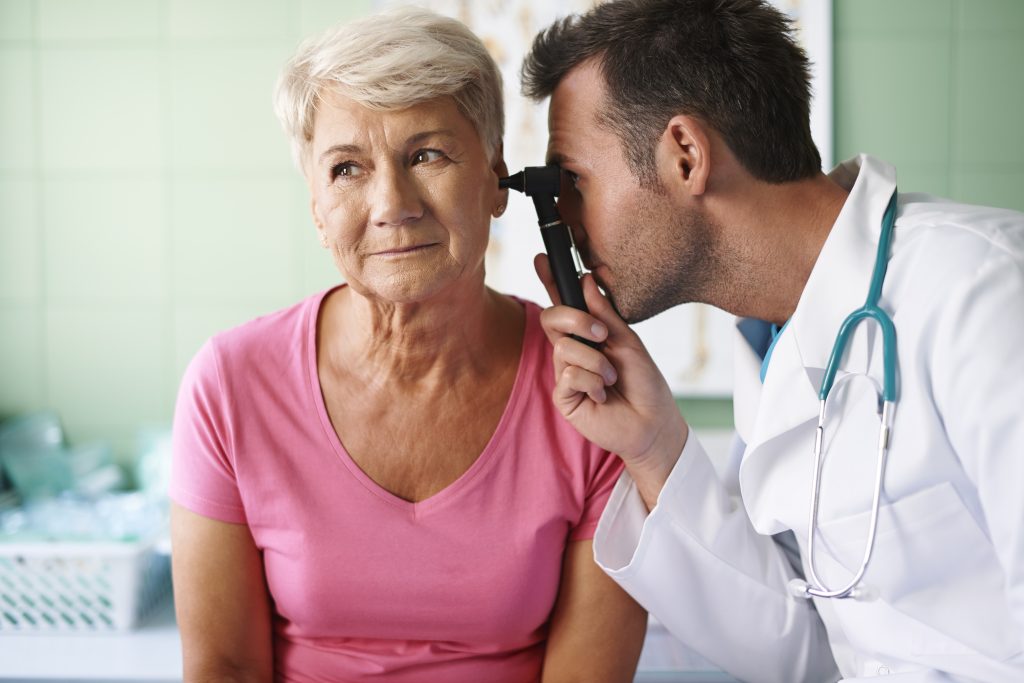 Doctor examinando la oreja de María, una mujer mayor en Centros Auditivos CONNECTA