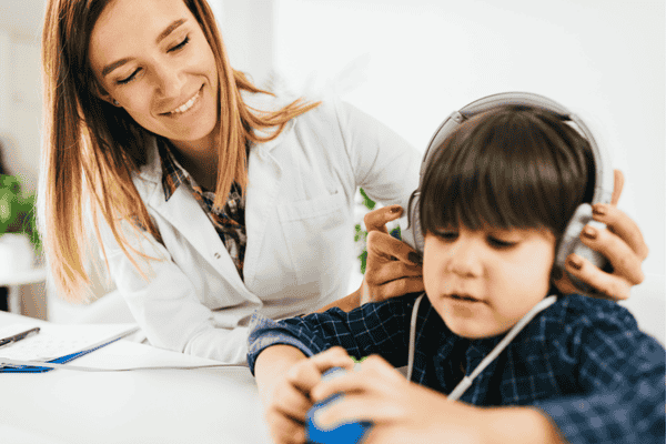 Niño realizando test auditivo en Ponferrada con auriculares especiales y supervisión profesional
