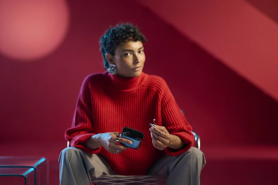 Usuario utilizando audífonos ReSound Vivia con estuche de carga portátil y control sencillo